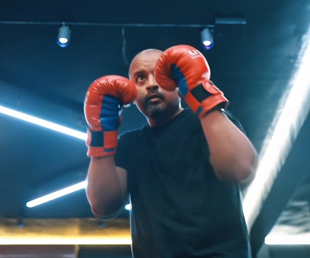 Vinay in boxing guard position with red gloves — real, unfiltered, mid-attempt